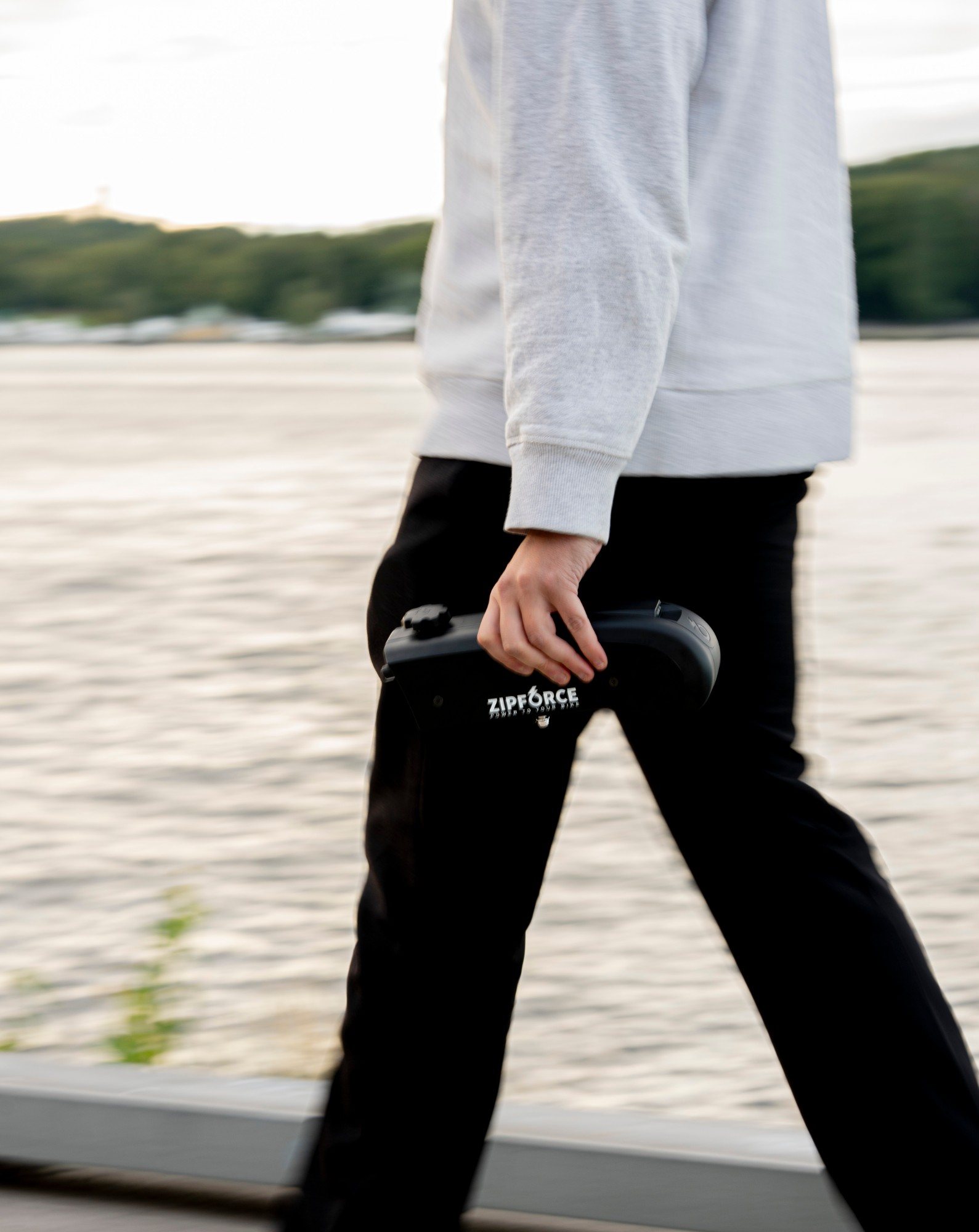 Someone walking by the water carrying the Zipforce motor in one hand