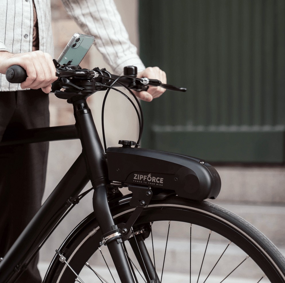 Zipforce motor on a black city bike, with the phone and app mounted on the handlebar